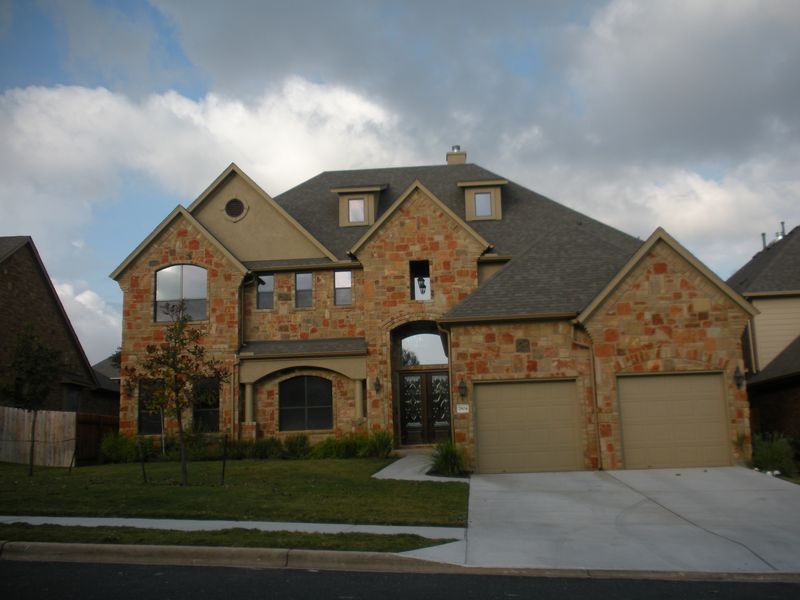 Newly built two-story stone and brick home with a two-car garage in a northwest Austin subdivision